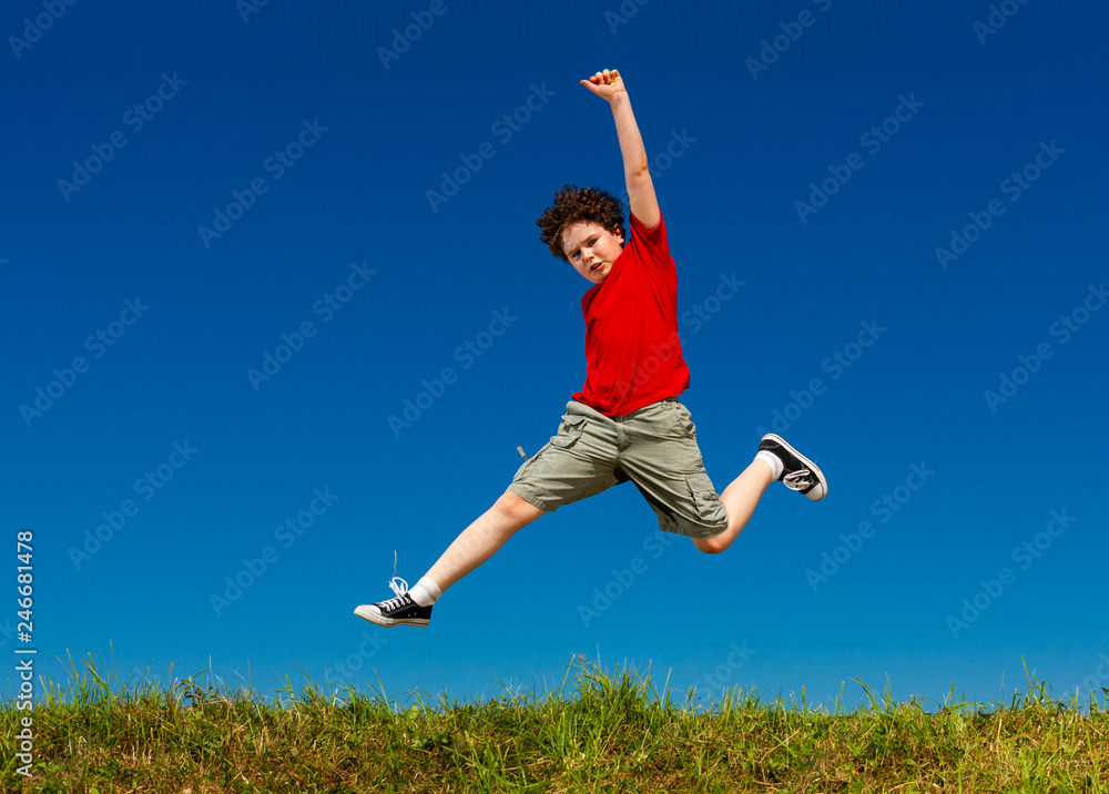 Boy jumping, running against blue sky Boy jumping, running against blue sky