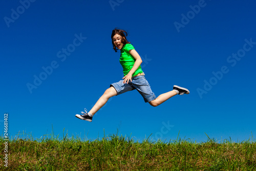 Girl jumping, running against blue sky