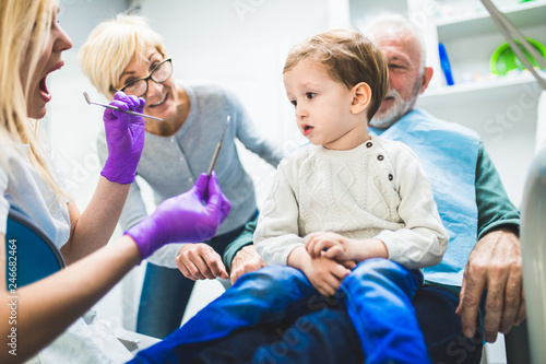 Two years old boy with his grandfather and grandmother first time on dental chair