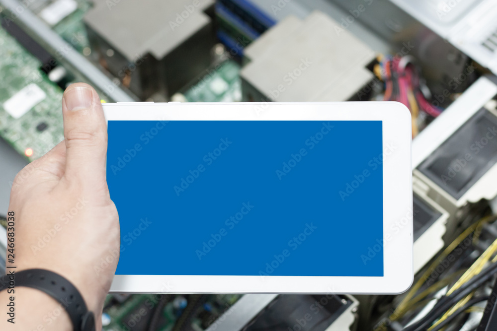 phone or tablet on hand at server equipment background. administering computer's local server. Diagnostic for server health. security and cloud technology. Mockup for design. phone or tablet on hand at server equipment background. administering computer's local server. Diagnostic for server health. security and cloud technology. Mockup for design.