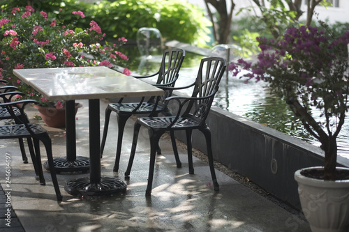 Set of garden furniture on the shady terrace near the pond