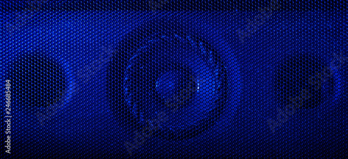 A close up macro photograph of a audio speaker using a blue flash gel