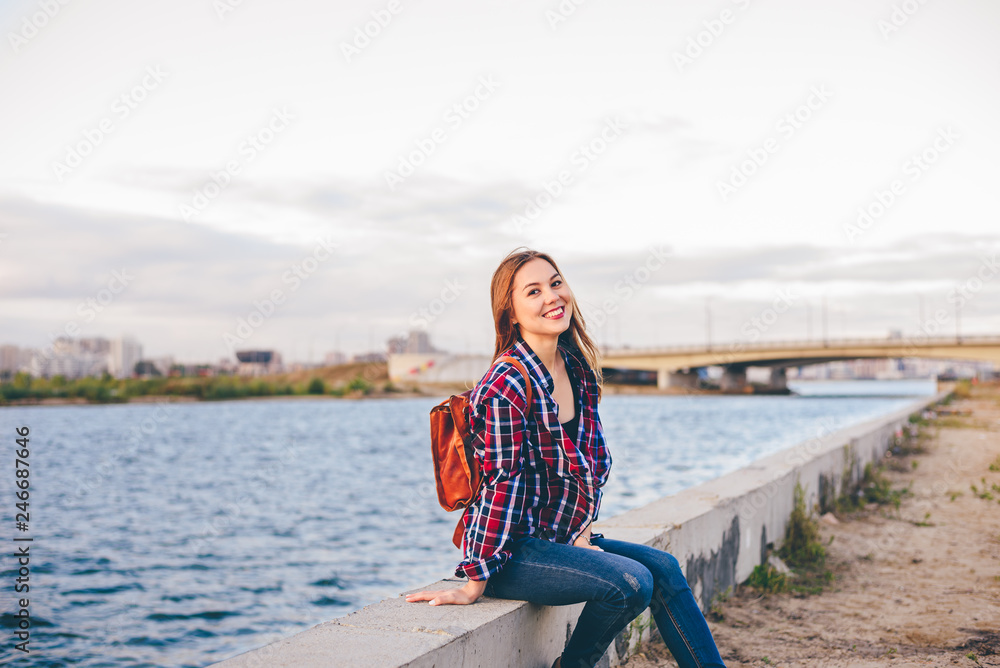 Smiling woman sitting on the riverbank