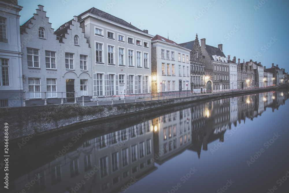 Reflection of houses in canal at night in Bruges, Belgium