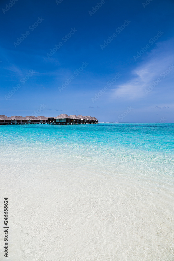 Water villas on the clear blue beach in the Maldives