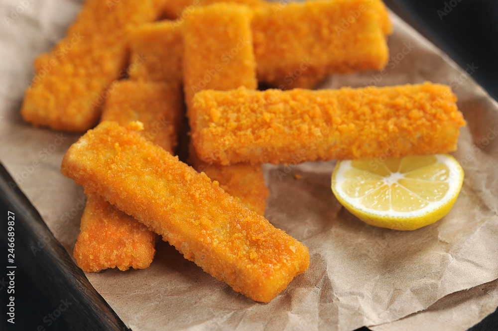 fried breaded fish sticks and lemon on paper fried breaded fish sticks and lemon on paper
