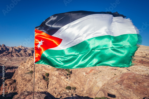 Flag of Jordan on a hill above Petra ancient city in Jordan