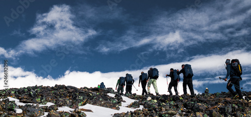 Group of people in a line hiking up the highest mountain in Sweden, Kebnekaise during a climb to reach the peak. 