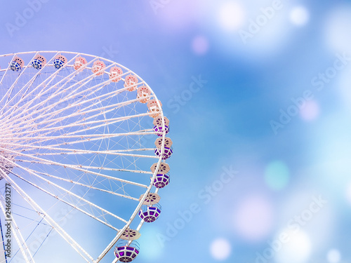 ferris wheel on the background of blue sky with colorful bright circles