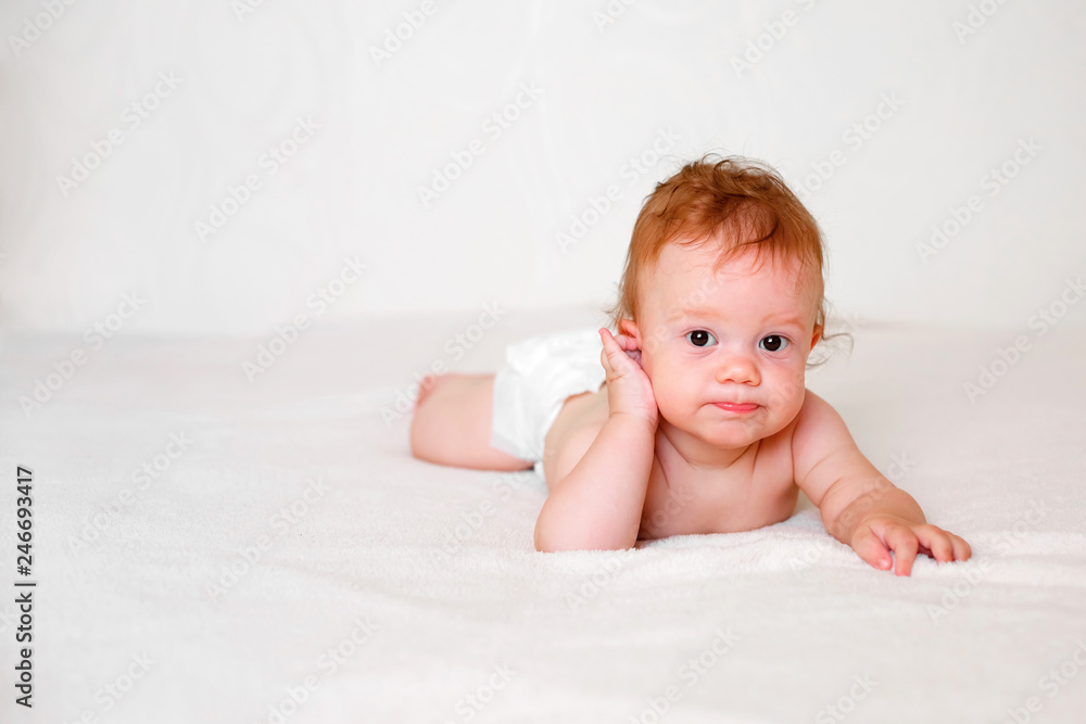 Portrait of cute redhead infant baby in diaper in light bedroom. Family, motherhood, love, health, innocence and care Portrait of cute redhead infant baby in diaper in light bedroom. Family, motherhood, love, health, innocence and care