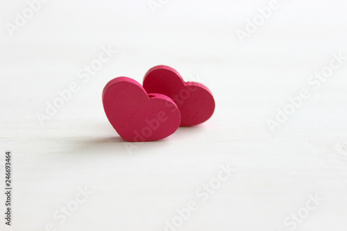 The concept of Valentine s day. Valentine s day background. Two pink hearts isolated on white wooden background. Copy space. Place for your text.