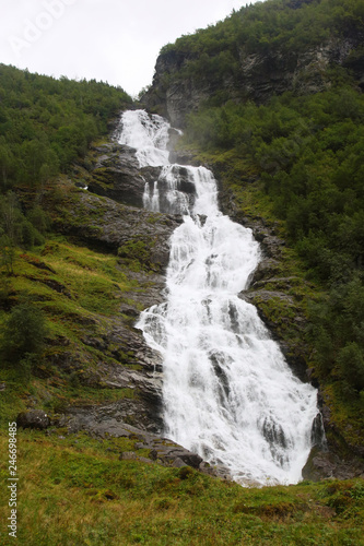 large waterfall in mountainous and wooded areas