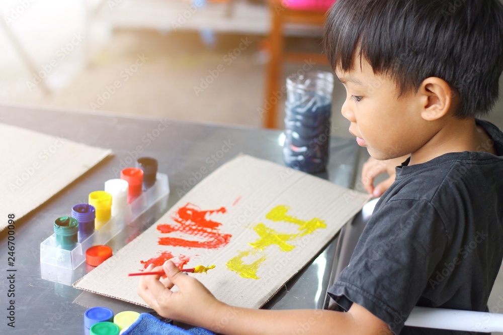 Kid and education concept, In the classroom, a student child boy drawing and painting colors on the paper. Kid and education concept, In the classroom, a student child boy drawing and painting colors on the paper.
