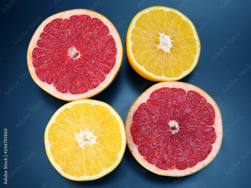 cut pieces of different citrus fruits on dark background cut pieces of different citrus fruits on dark background