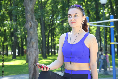 cute young sporty girl listening to music on a walk