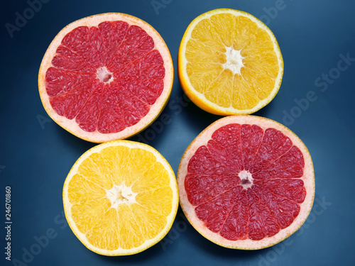 cut pieces of different citrus fruits on dark background