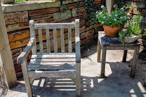 Weathered chair and side table hidden in the shadows