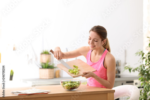 Young woman in fitness clothes preparing healthy breakfast at home