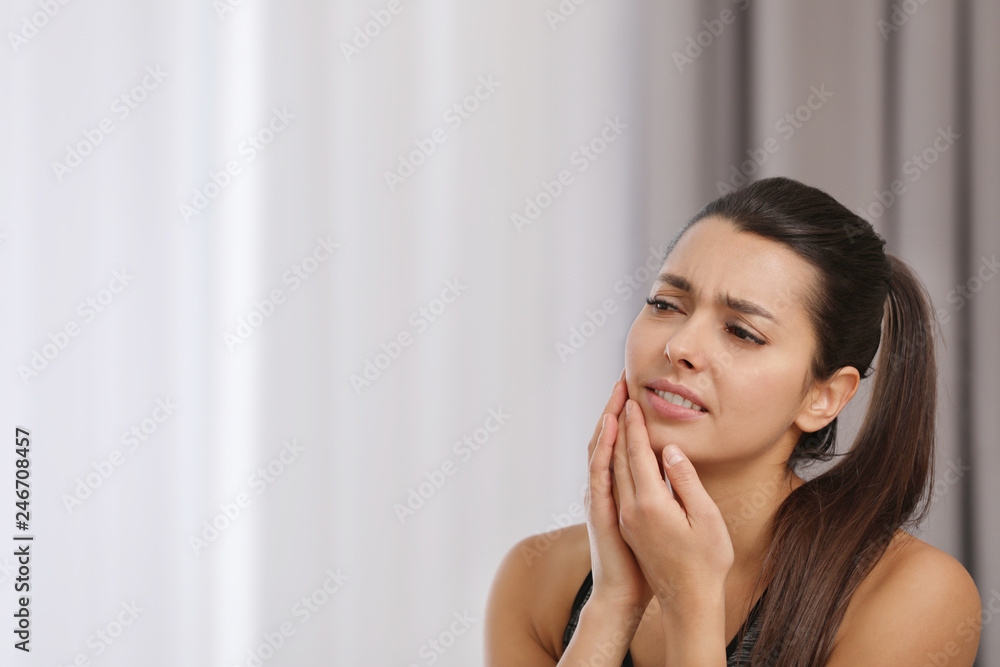 Young woman with sensitive teeth indoors. Space for text Young woman with sensitive teeth indoors. Space for text