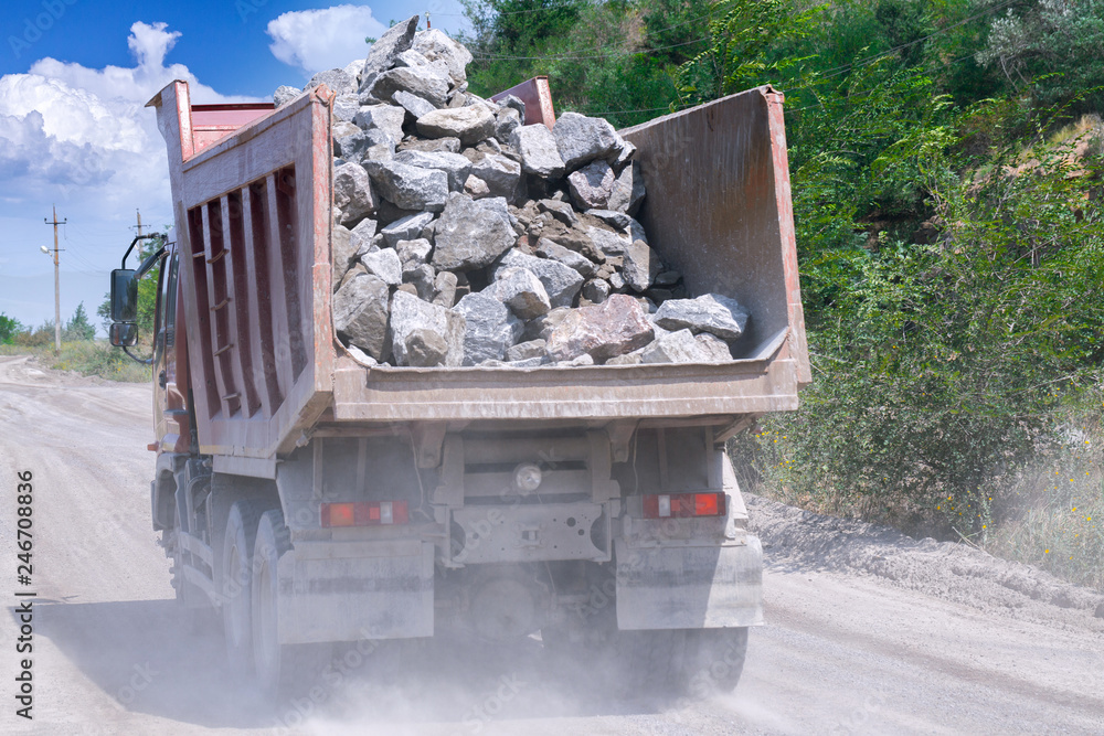 A dump truck loaded mined granite in a quarry open pit mining of