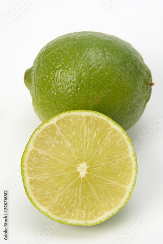Cut citrus fruit of green lemon on white background