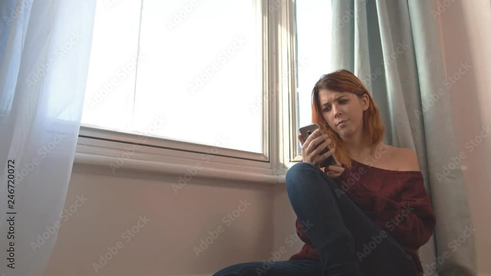 Young woman uses a smartphone, looks concerned. Dolly by. Young woman uses a smartphone, looks concerned. Dolly by.