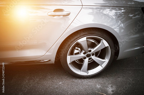 Warm light shine on Car wheels close up on a background of asphalt. Car tires. 