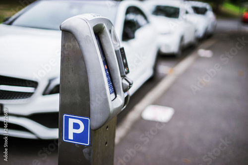 Parking machine or Parking meters with electronic payment in the city streets and a row of cars in Sydney Australia.