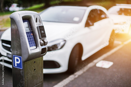 Parking machine or Parking meters with electronic payment in the city streets and a row of cars in Sydney Australia.