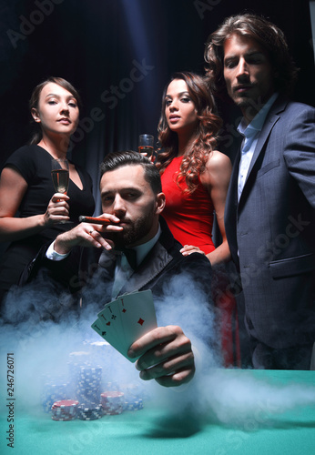Rich handsome man smoking cigar and playing in the casino