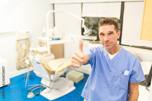 Professional male dentist smiling at camera in office