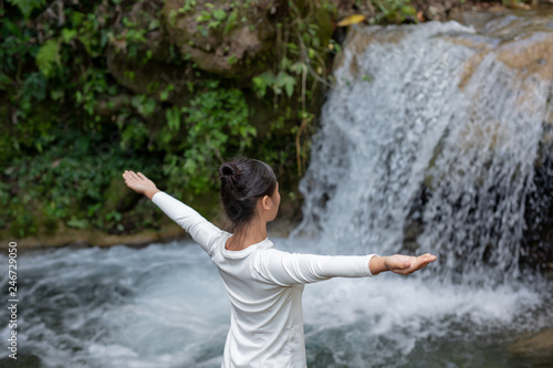 Beautiful girls are playing yoga at the park. Among the natural waterfalls in the forest  exercise concepts