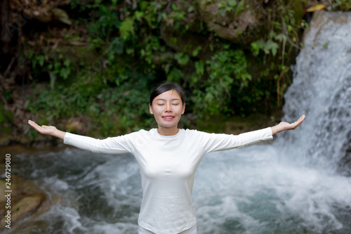 Beautiful girls are playing yoga at the park. Among the natural waterfalls in the forest  exercise concepts