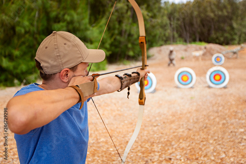 Behang man practicing archery