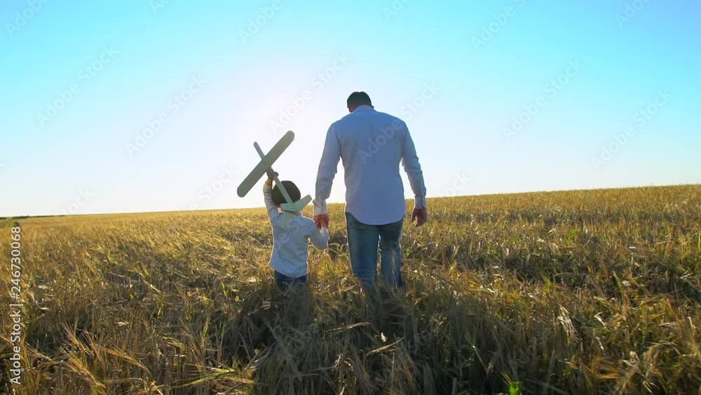 silhouette of father and son playing, walking with airplane toy together at sunset in wheat field. happy family outdoors. Child boy having fun, airplane flying in sky, flight travel nature summer day silhouette of father and son playing, walking with airplane toy together at sunset in wheat field. happy family outdoors. Child boy having fun, airplane flying in sky, flight travel nature summer day