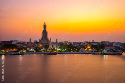 Wat Arun Temple Beside Chao Phraya River at Twilight Time in Bangkok, Thailand. One of the Most Famous Place of Thailand's Landmarks. Beautiful Sunset Sky with Smooth Water.
