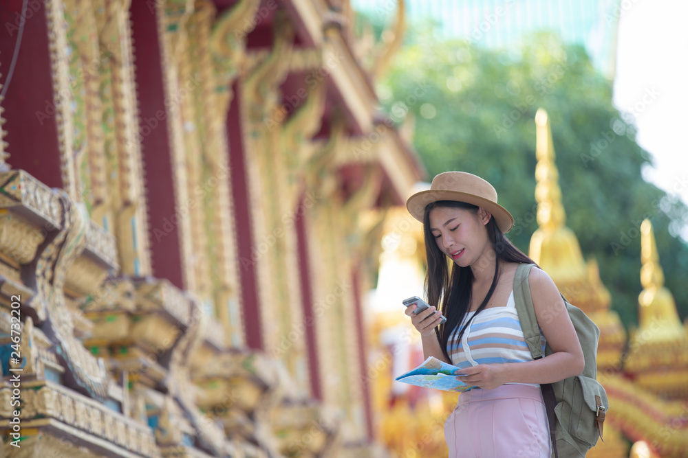 Female tourists take pictures with mobile phones