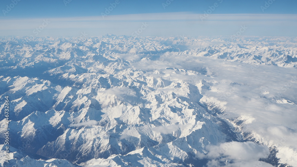 Aerial landscape of the Alps in Europe during winter season with fresh snow. View from the window of the airplane