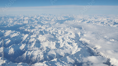 Aerial landscape of the Alps in Europe during winter season with fresh snow. View from the window of the airplane