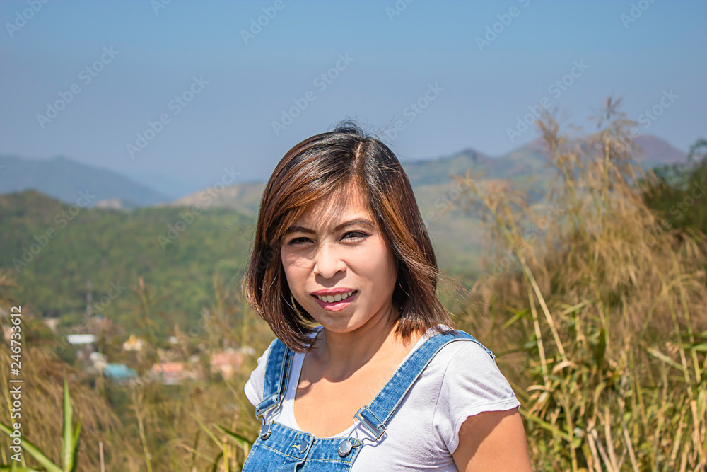 Portrait of Asean Woman The background of mountains and sky at Nern Chang Suek hills, Kanchanaburi, Thailand Portrait of Asean Woman The background of mountains and sky at Nern Chang Suek hills, Kanchanaburi, Thailand