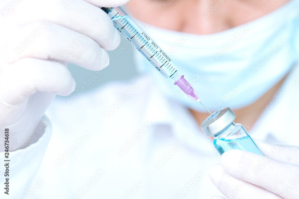 Hand of doctor holding syringe and medicine bottle. Preparing for injection Hand of doctor holding syringe and medicine bottle. Preparing for injection