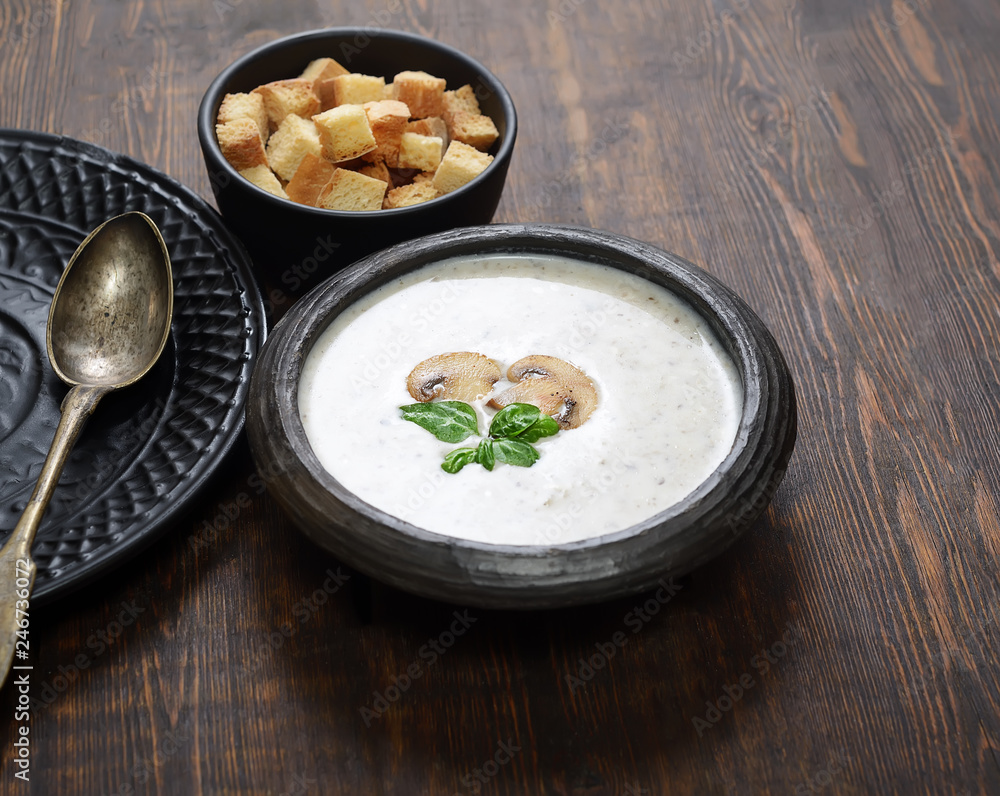 Champignon mushroom cream soup in bowl on wooden background. Rustic style. Champignon mushroom cream soup in bowl on wooden background. Rustic style.