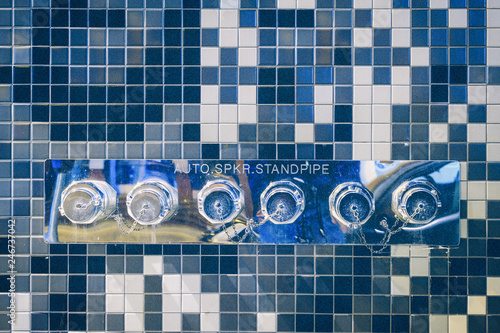 Blue tonality of tile wall with industrial sprinkler inlets