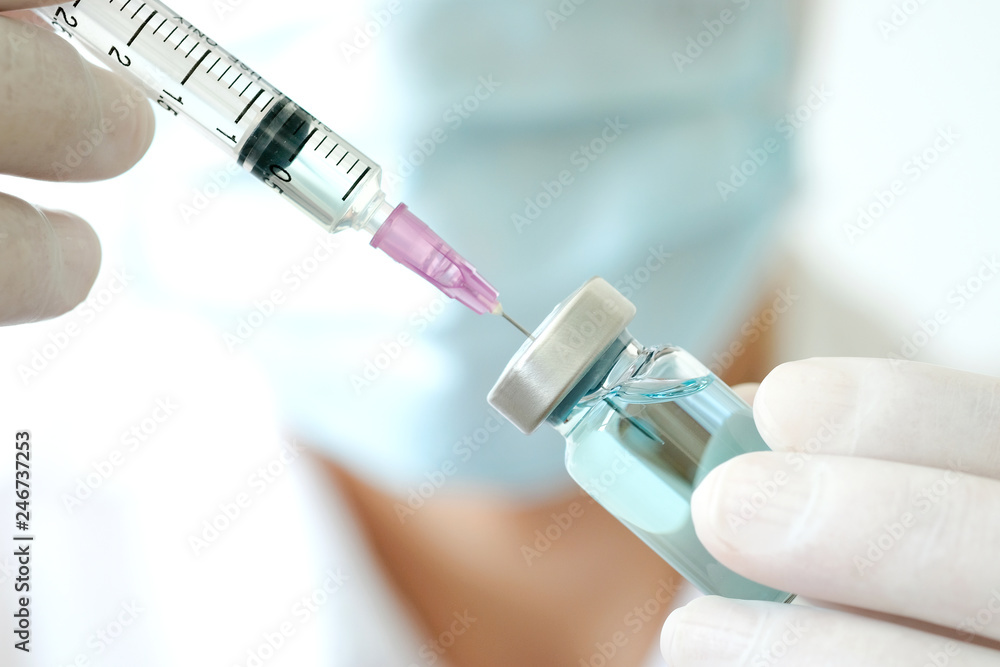 Hand of doctor holding syringe and medicine bottle. Preparing for injection Hand of doctor holding syringe and medicine bottle. Preparing for injection