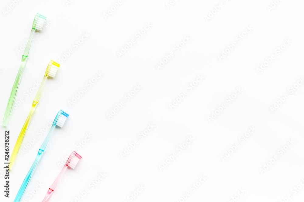 Clean teeth. Colorful plastic toothbrushes on white background top view space for text Clean teeth. Colorful plastic toothbrushes on white background top view space for text