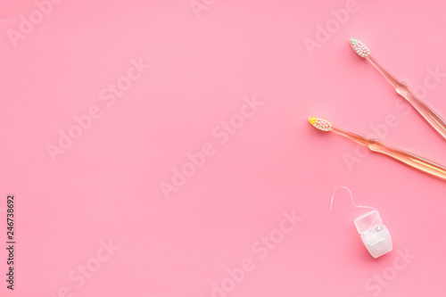 Oral hygiene. Plastic toothbrushes on pink background top view copy space