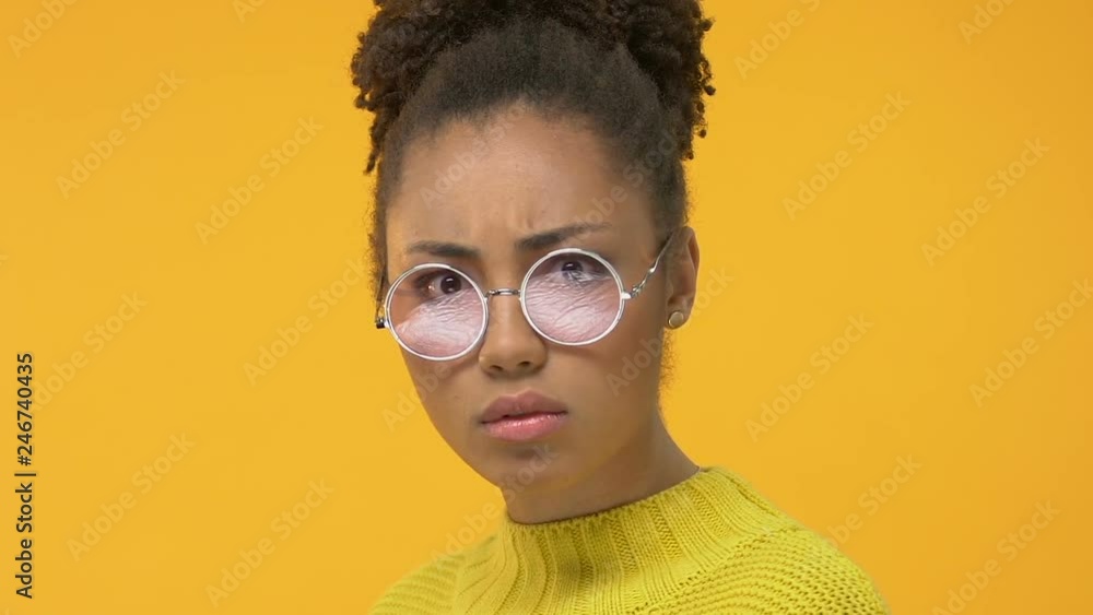 Young african student drinking hot beverage cup and looking sadly into camera Young african student drinking hot beverage cup and looking sadly into camera
