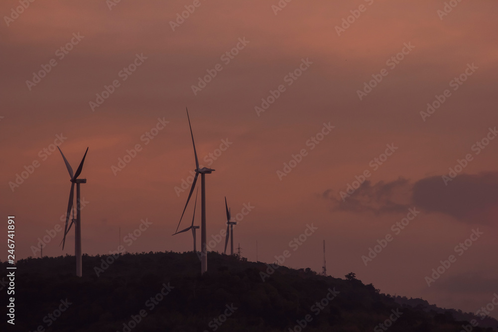 Obraz premium Silhouette of wind turbines generating electricity on the mountain.