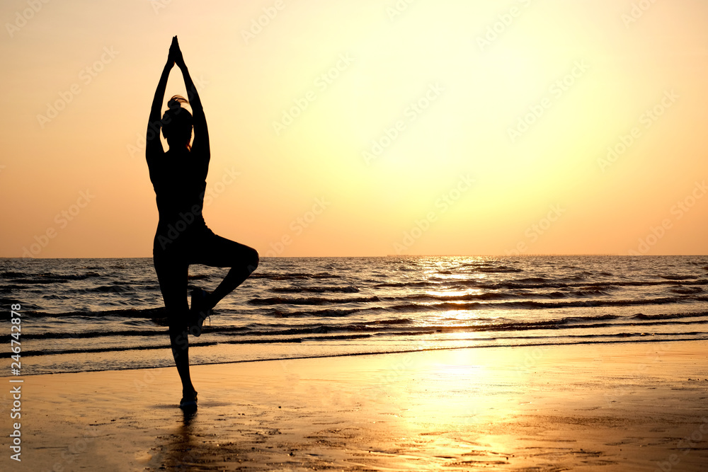 Morning of a new day,  woman playing yoga and stretching muscles on the beach sunlight in morning. Health concept.