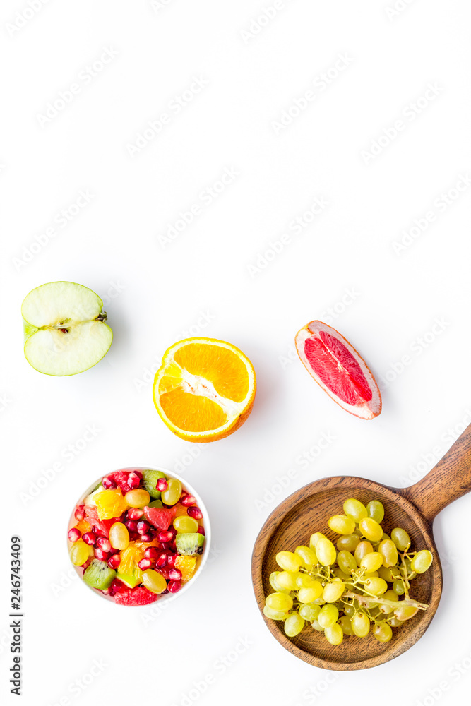 Healthy diet concept. Fruit salad near fresh fruits on white background top view space for text Healthy diet concept. Fruit salad near fresh fruits on white background top view space for text